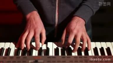 正面的乐手在舞台上玩数字钢琴在彩色聚光灯下，乐队表演歌曲高角度